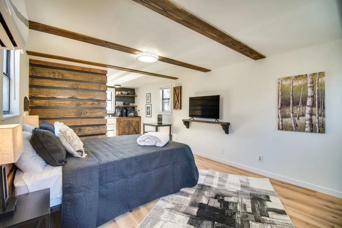 A bedroom with a large bed and a flat screen tv.