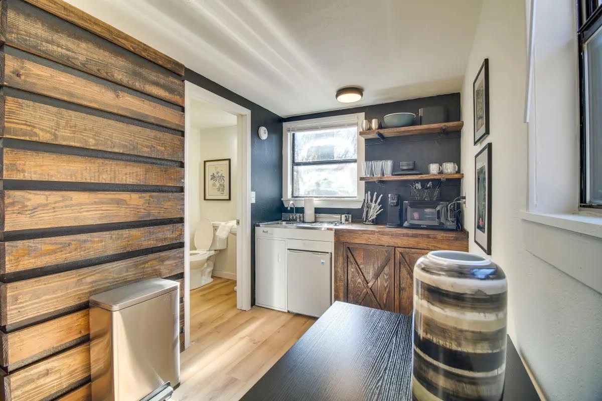 A kitchen with a wooden wall and a table and a vase on the table.