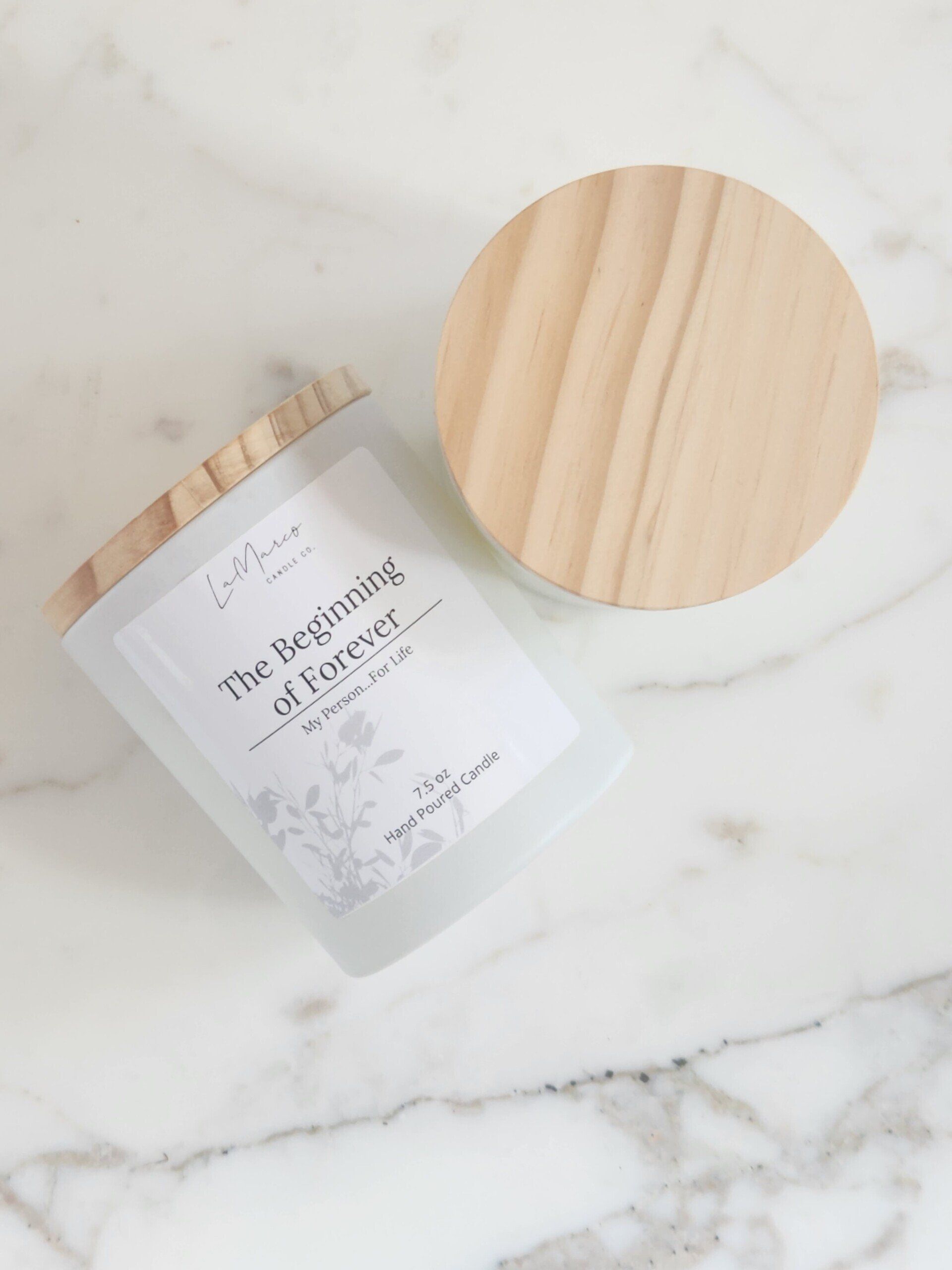 Candle with wooden lid on marble, label reads 