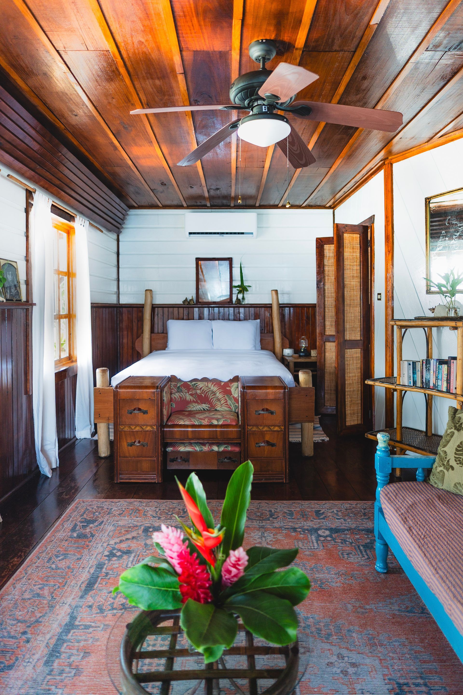 A bedroom with a ceiling fan and a bed.