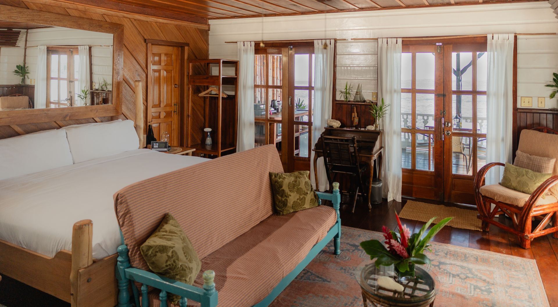 A living room with a couch , chair , and bed.