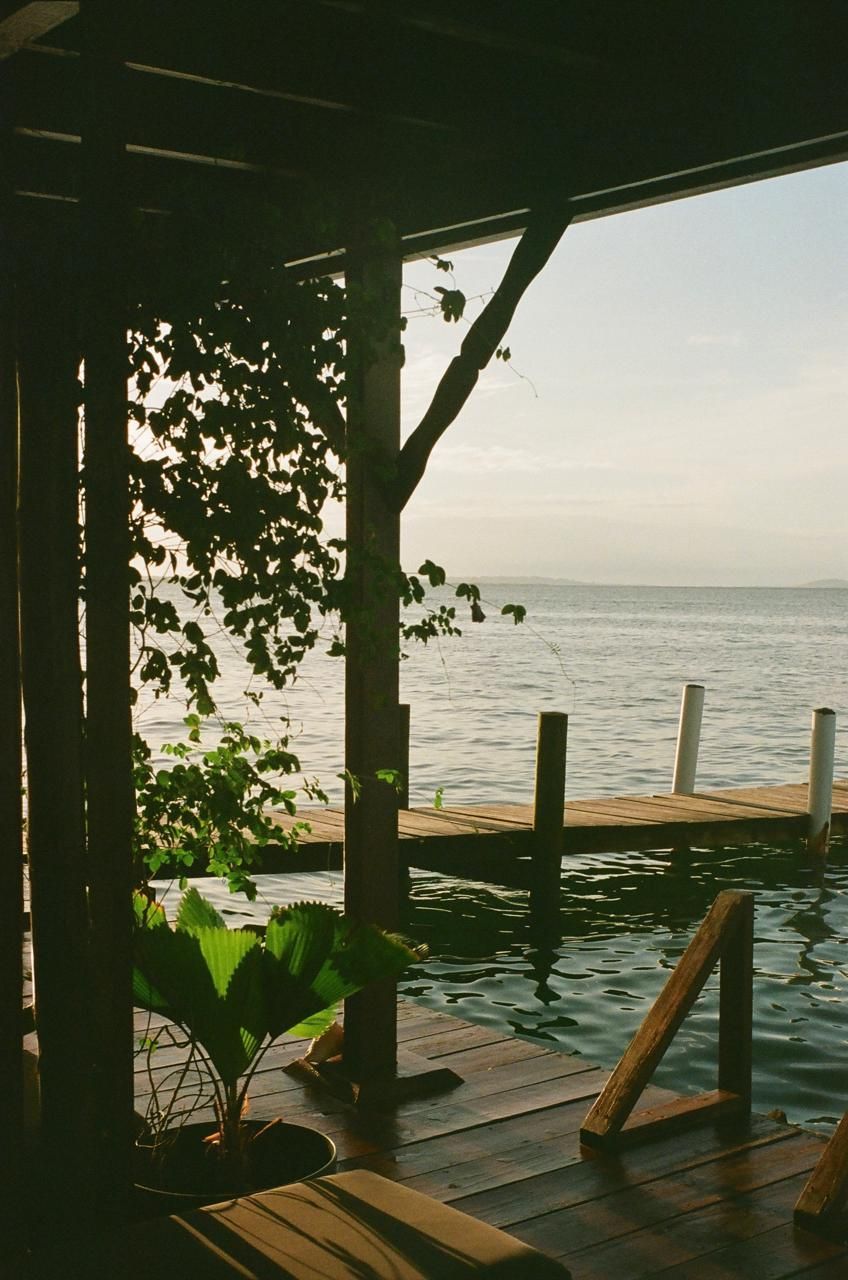 A wooden deck overlooking a body of water with a dock in the background