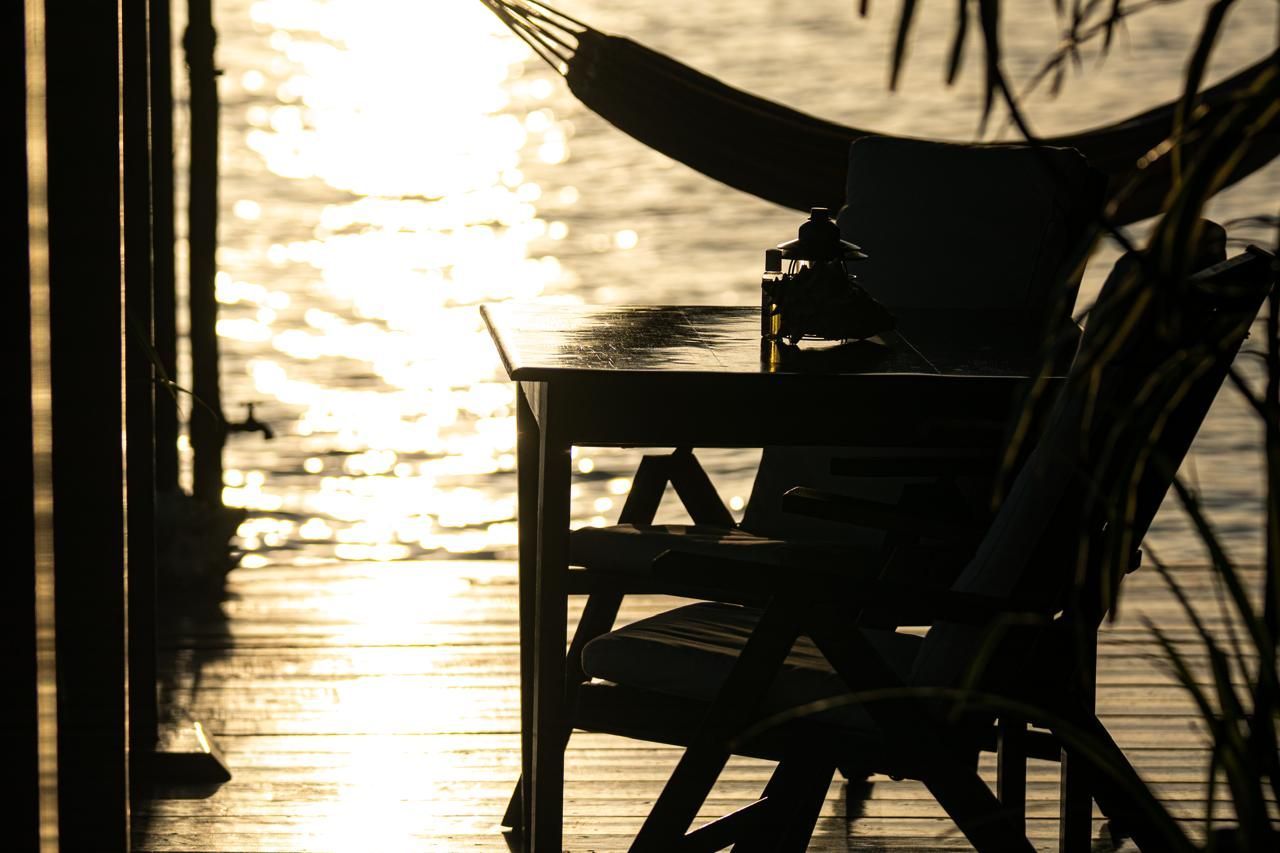 A hammock is hanging over a table and chair on a dock