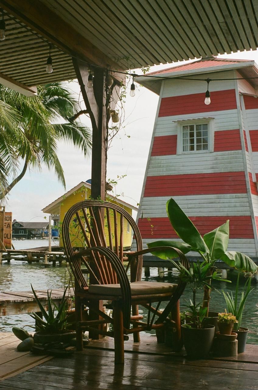 A chair is sitting on a porch next to a red and white striped building.