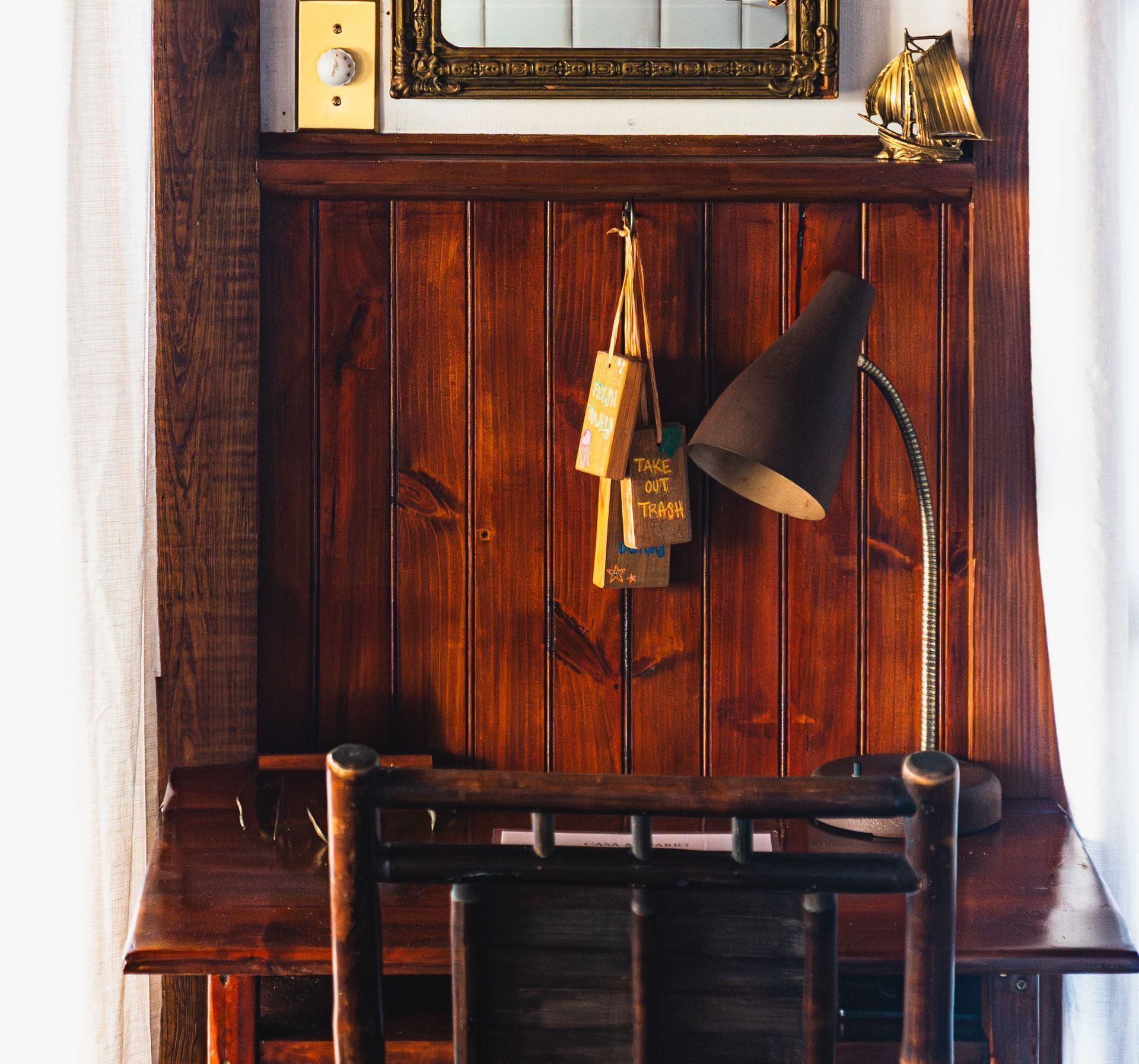 A wooden desk with a lamp and a mirror