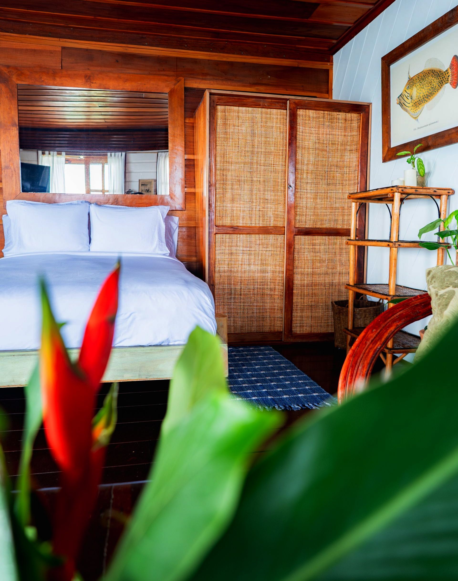 A bedroom with a bed and a wicker wardrobe