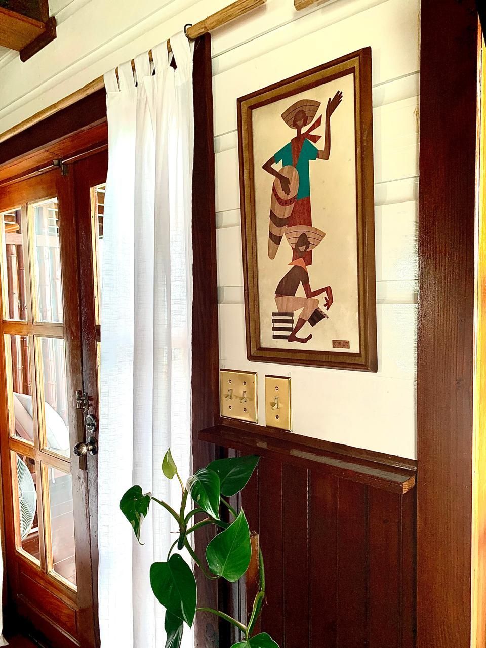 A picture of a man playing a guitar hangs on a wall next to a door