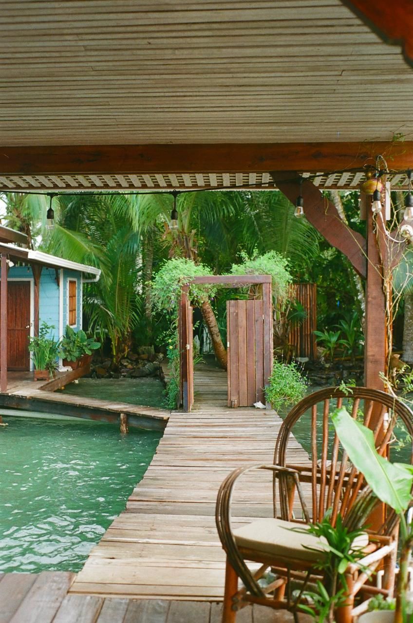 A wooden deck with chairs and a table overlooking a body of water