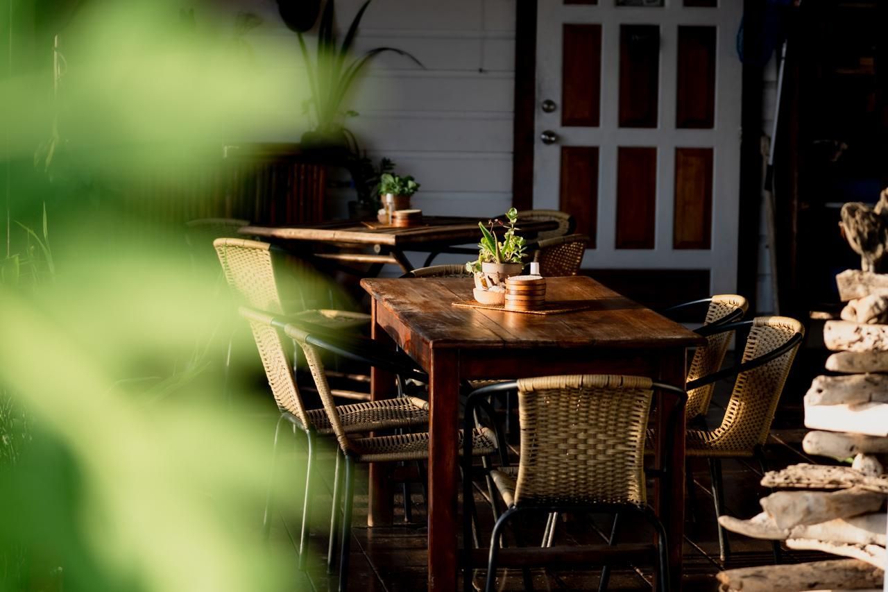 A row of wooden tables and chairs in a restaurant.