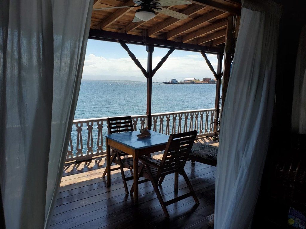 A table and chairs on a balcony overlooking the ocean