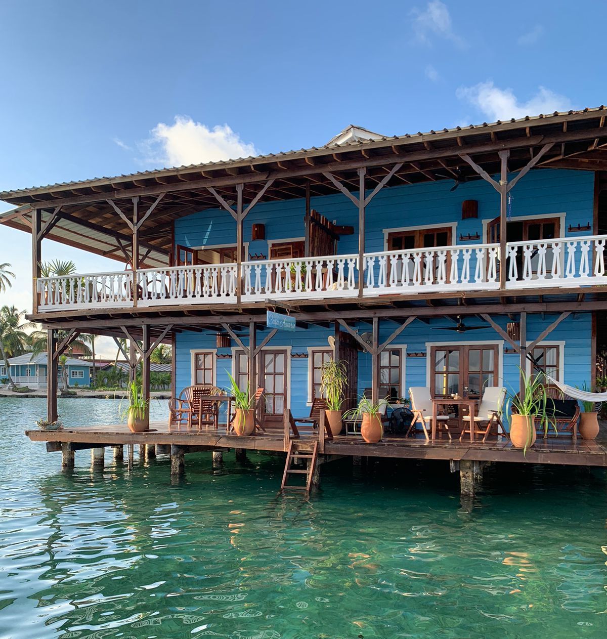 A blue building with a balcony overlooking a body of water