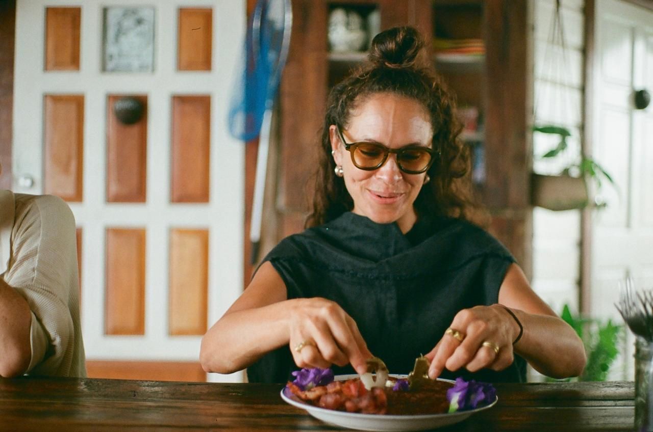 A woman is sitting at a table eating a plate of food.