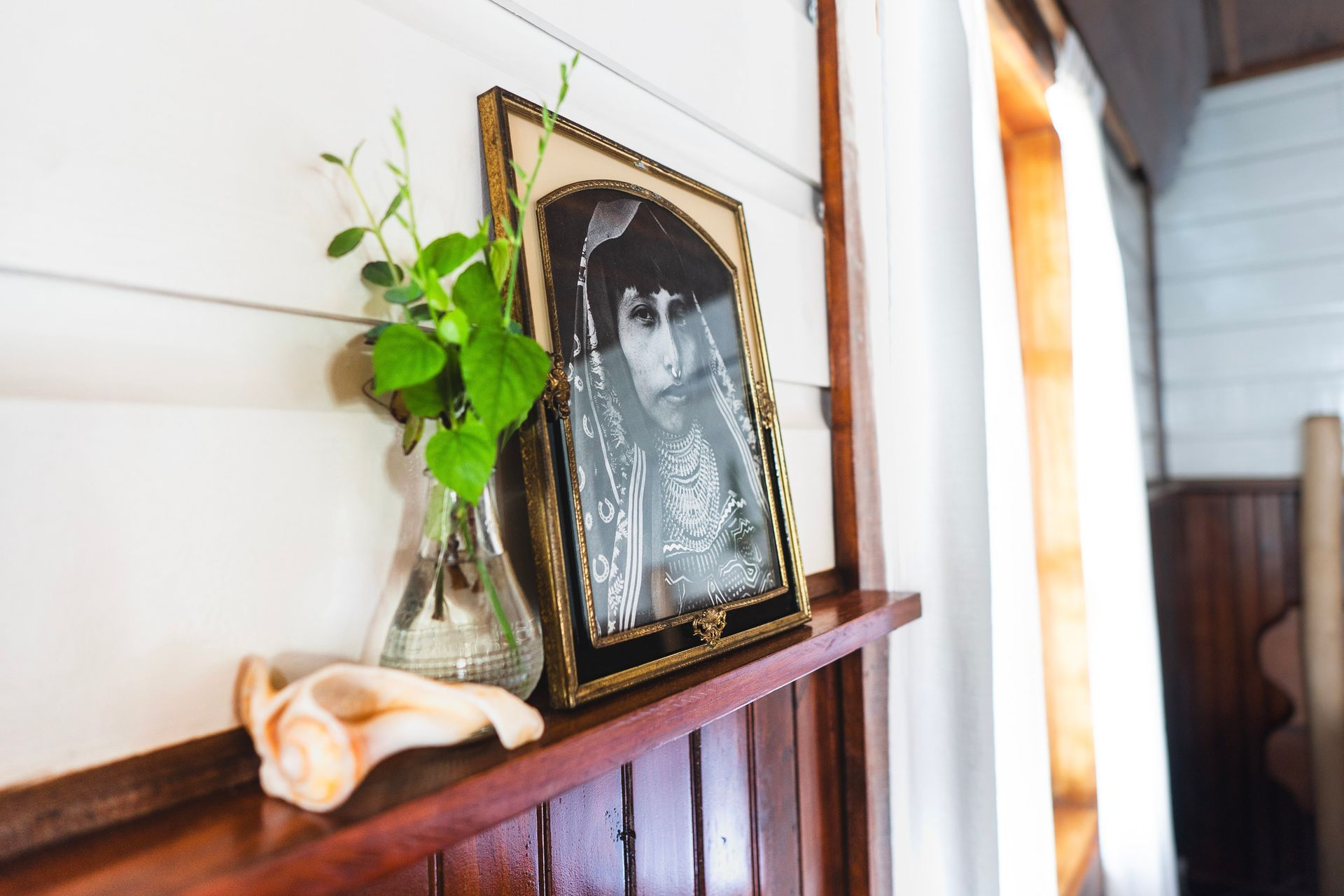 A picture of a Panamanian woman in a Mola dress is on a wooden shelf.