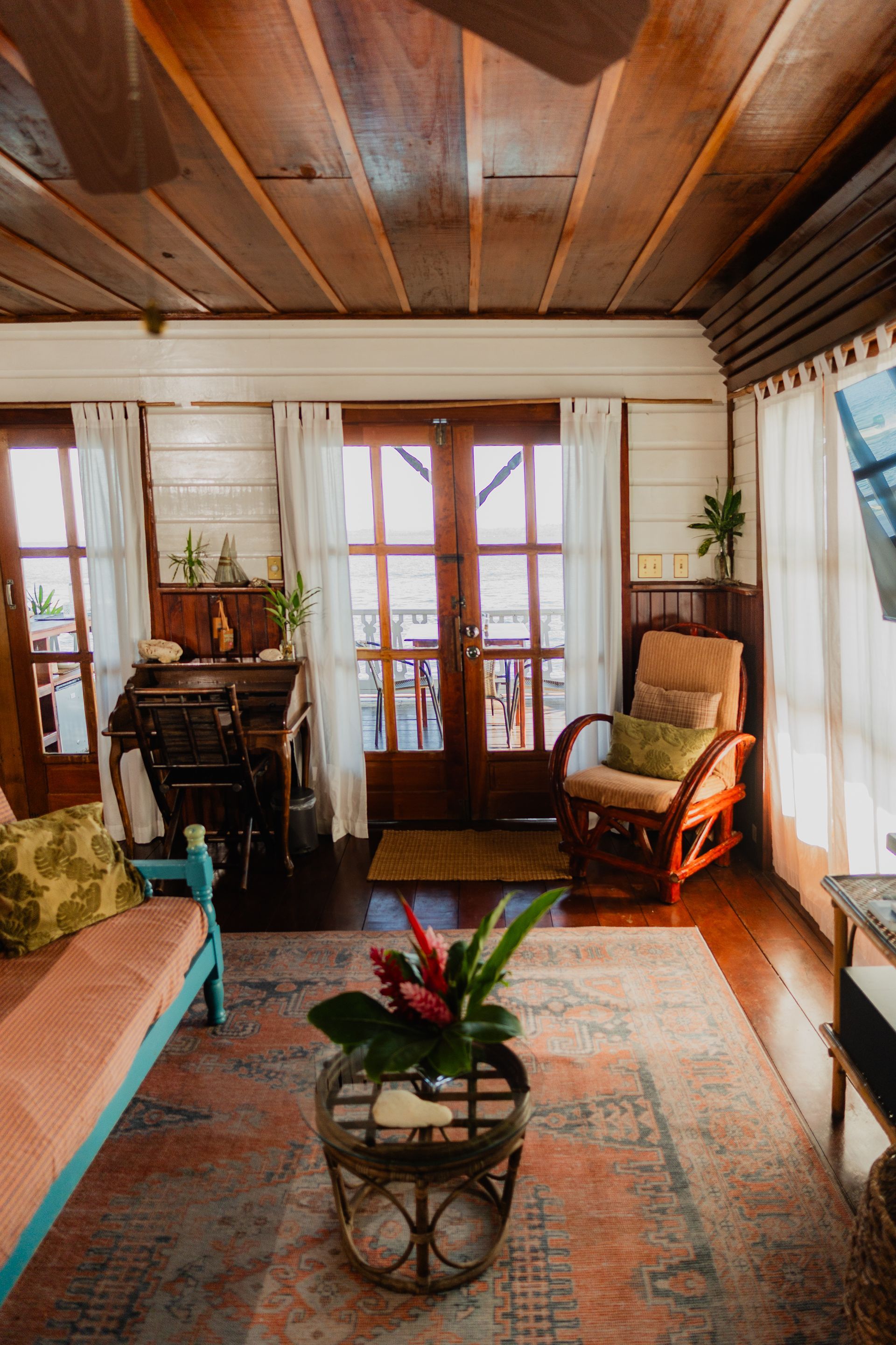 A living room with a couch , chair , table and a ceiling fan.