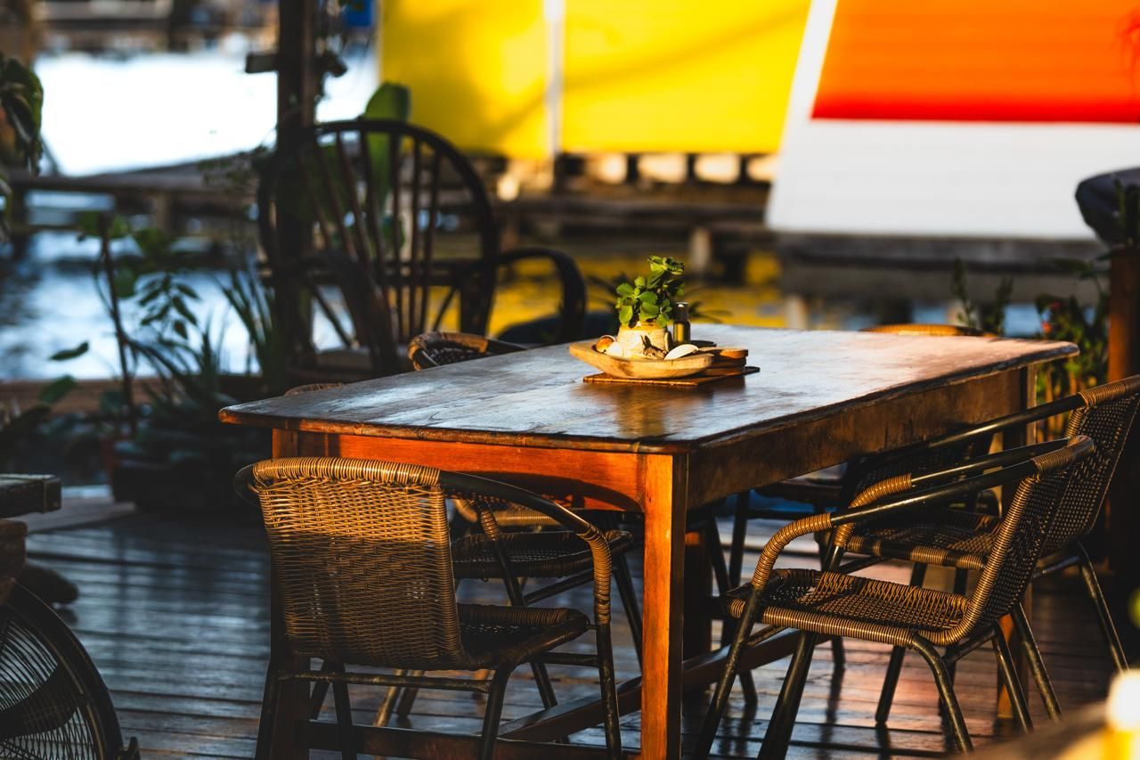 A wooden table and chairs are sitting on a wooden deck.