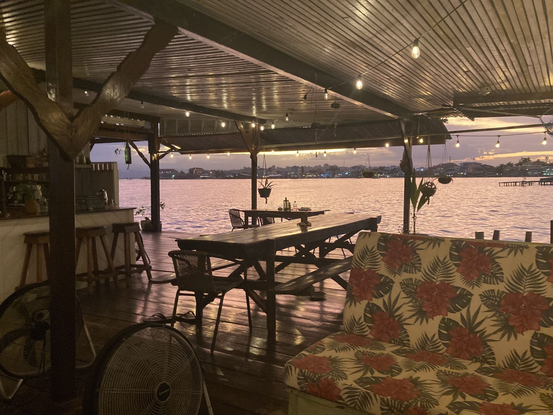 A room with tables and chairs overlooking a body of water