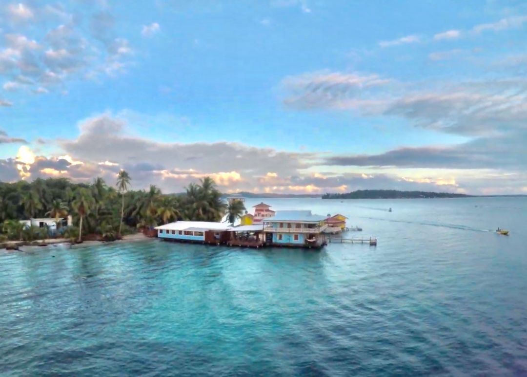 An aerial view of a boat and Casa Acuario in the middle of the ocean.