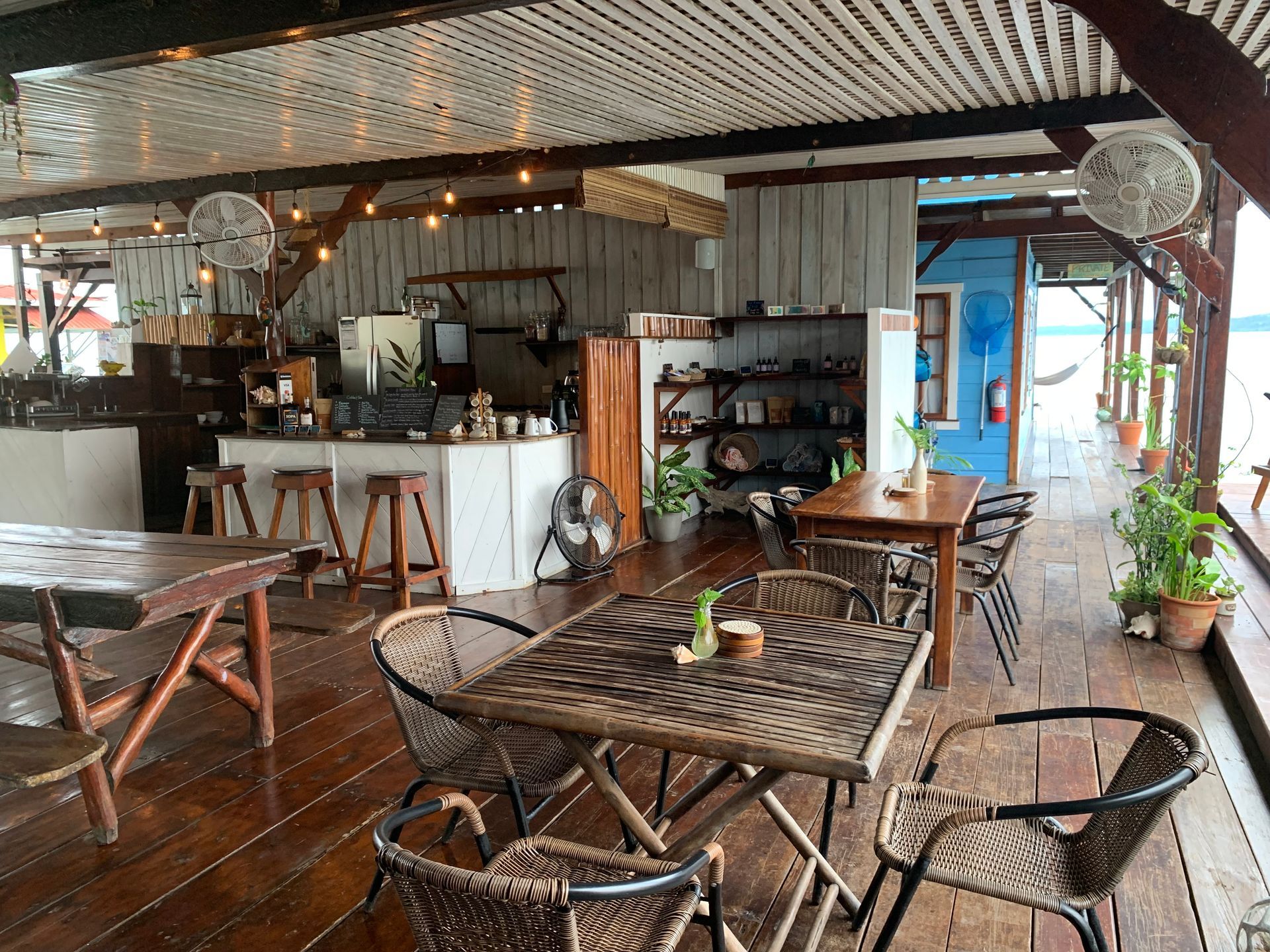 A restaurant with tables and chairs on a wooden floor.