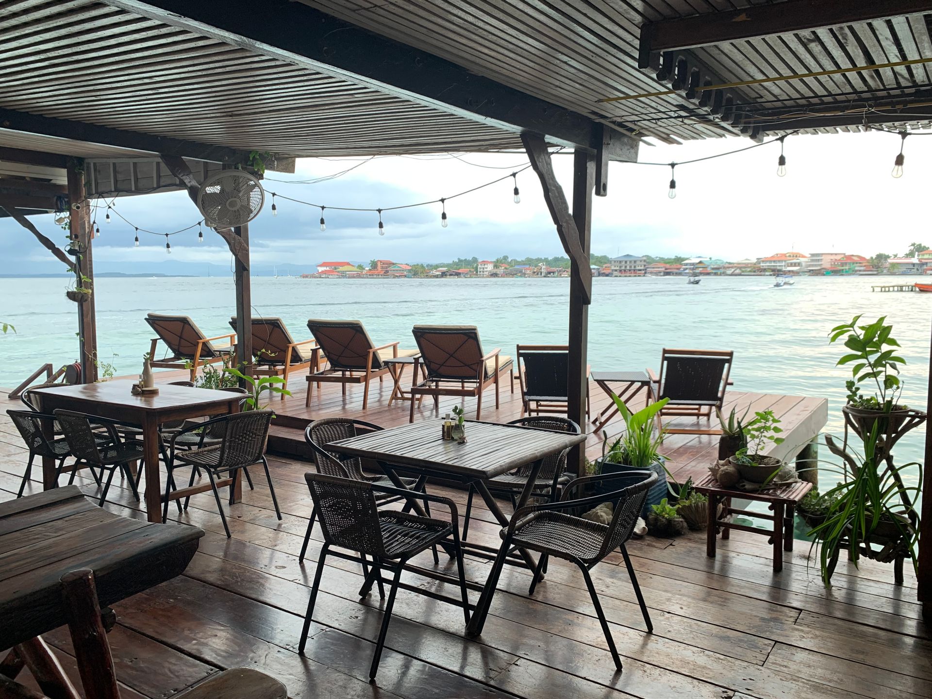 A restaurant with tables and chairs overlooking the ocean.