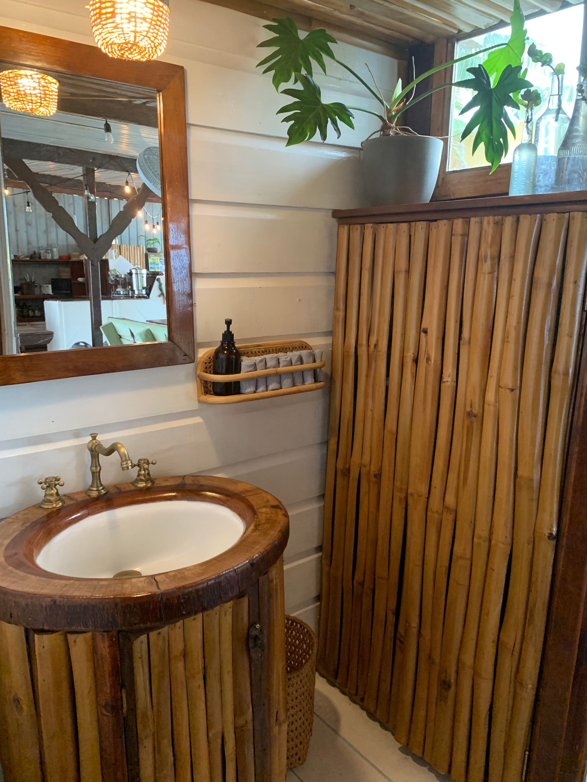 A bathroom with a sink , mirror and a wooden wall.
