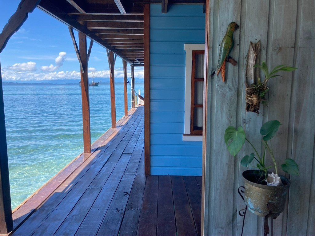 A blue house with a balcony overlooking the ocean