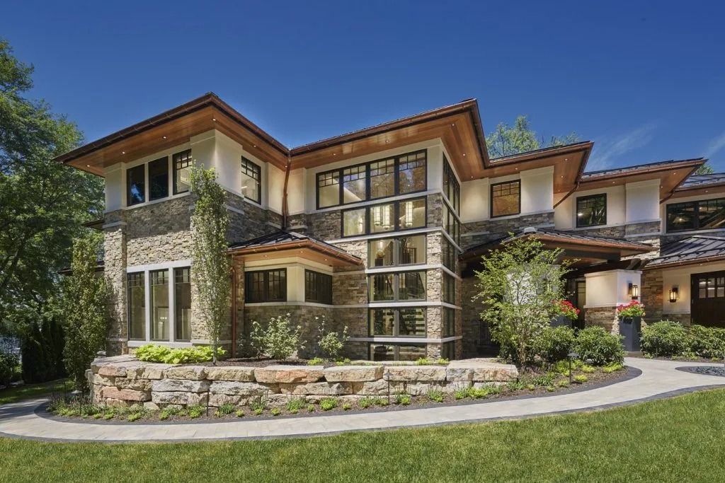Stone and glass house with terracotta roof on a sunny day.