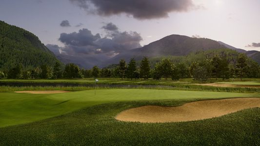 A man is swinging a golf club at a golf ball on a golf course.