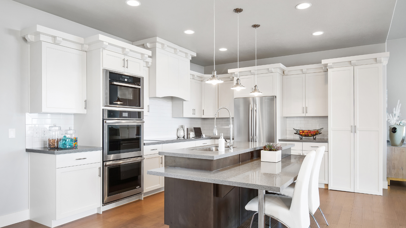 White modern kitchen with island and stainless steel appliances.