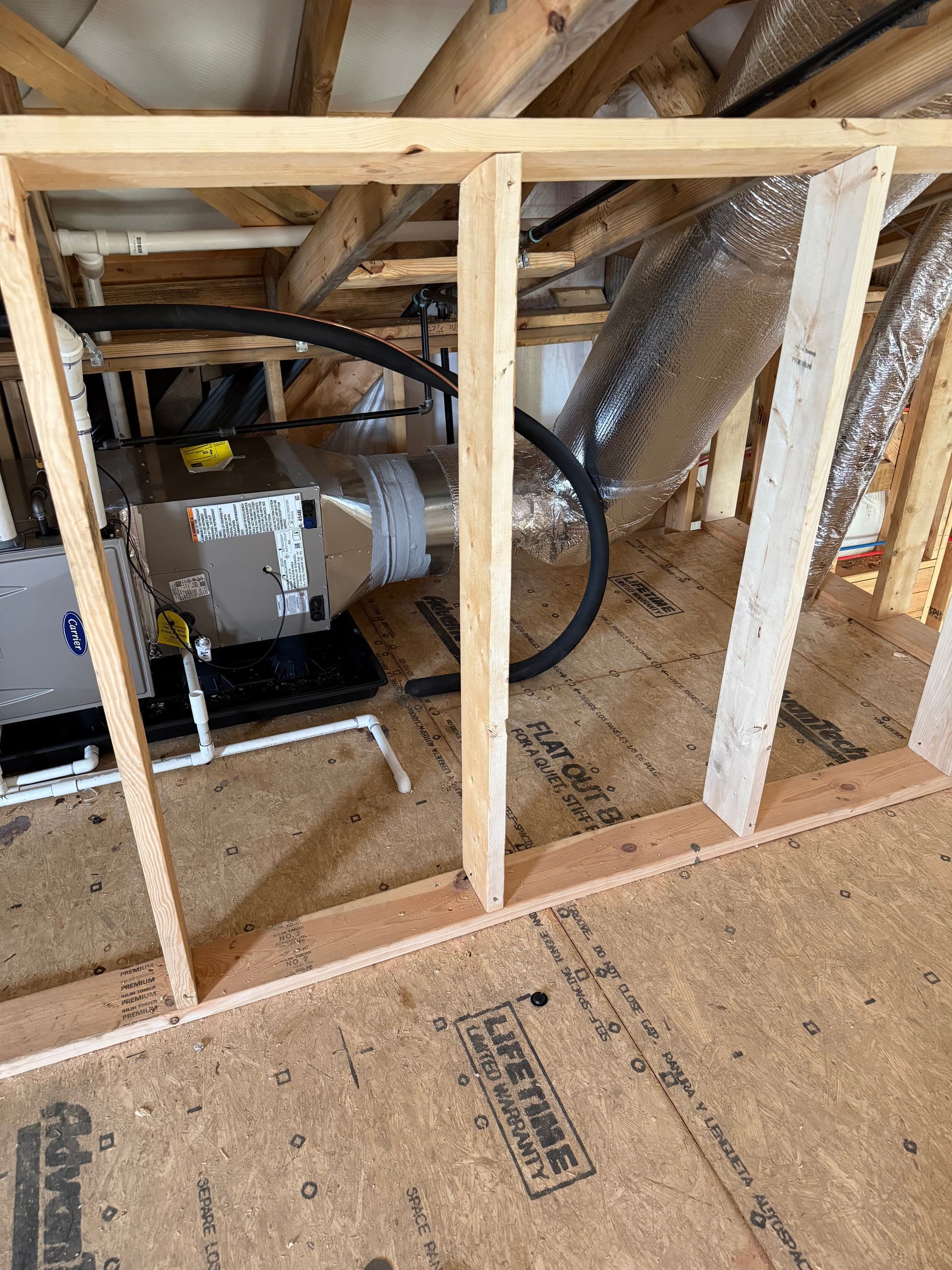 HVAC system in a wooden framed area. Ductwork and framing visible; light wood, silver, and black.