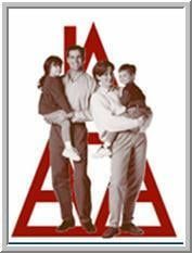 Two men holding a child each, in front of a red triangular logo.