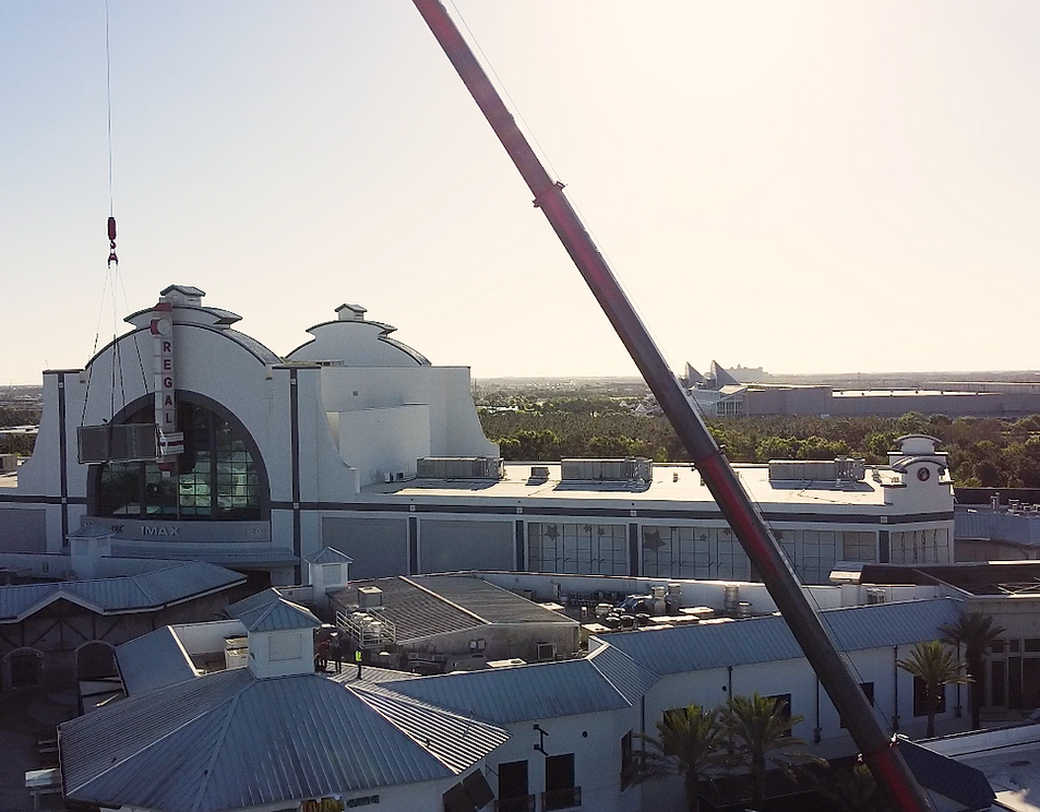 An aerial view of a large building with a crane in the foreground
