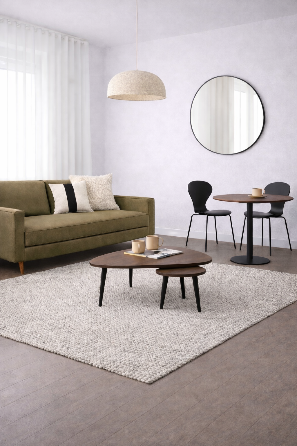 Salon avec canapé vert olive, miroir rond et petite table.