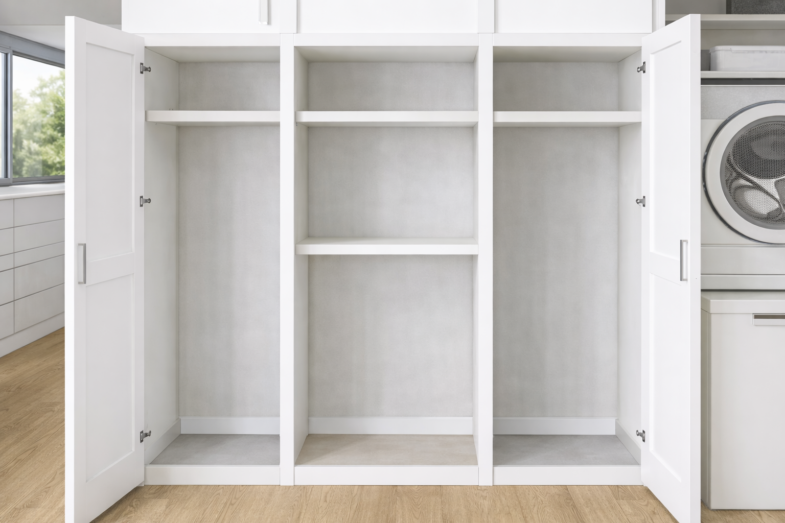 Dans une buanderie, on aperçoit des placards de rangement ouverts blancs avec des étagères, une machine à laver.