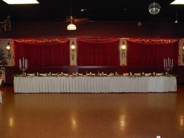 A long white table in a room with red curtains