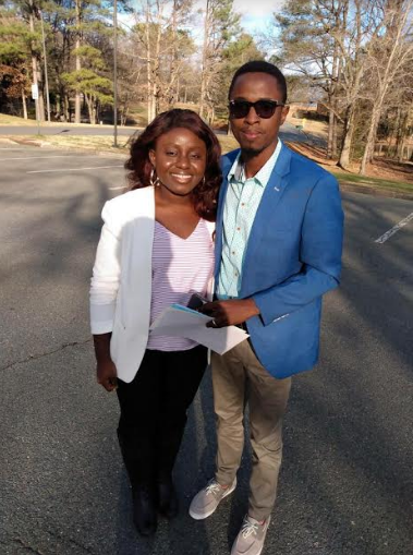 A man in a blue jacket stands next to a woman in a white jacket