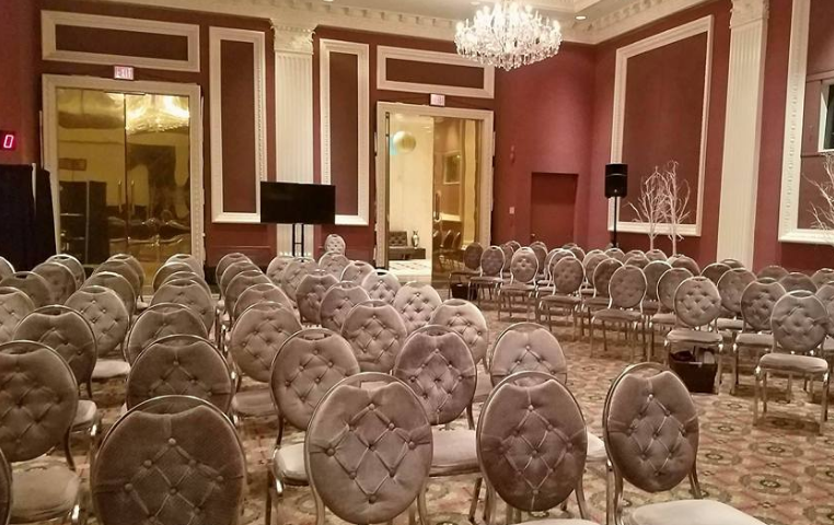 A large room filled with rows of chairs and a chandelier.
