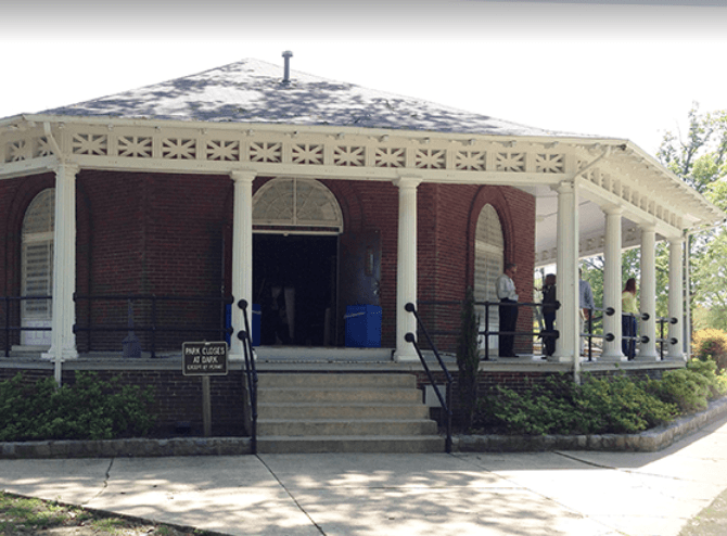 A brick building with a white porch and stairs