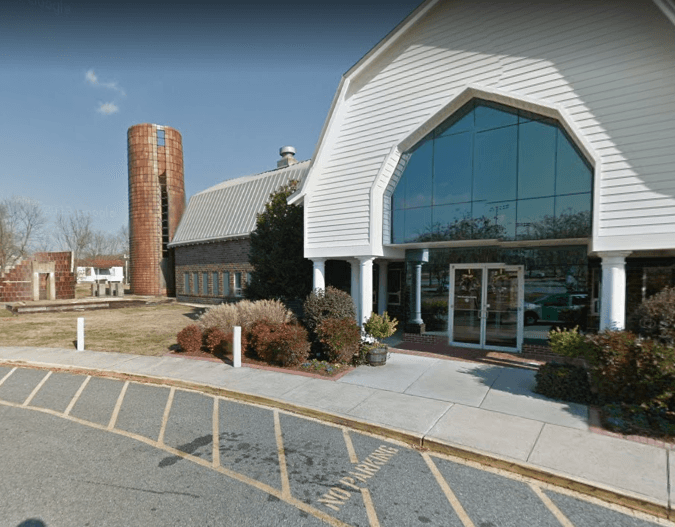 A large building with a silo in the background