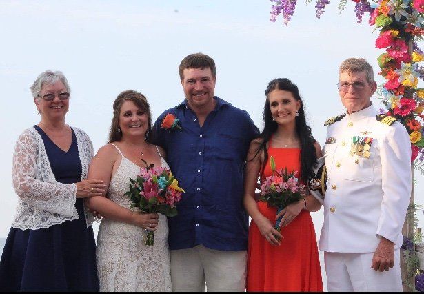 A group of people posing for a picture at a wedding