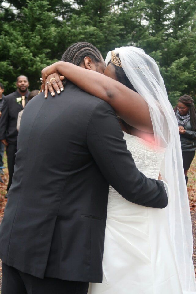A bride and groom kissing in front of a crowd of people