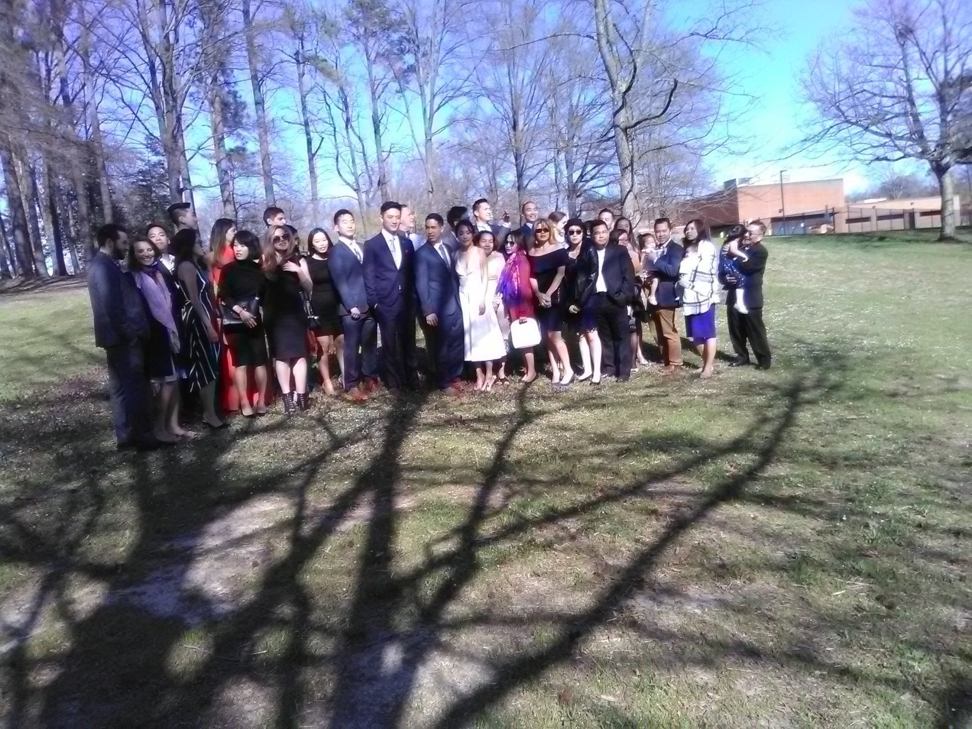 A group of people are posing for a picture in a park.