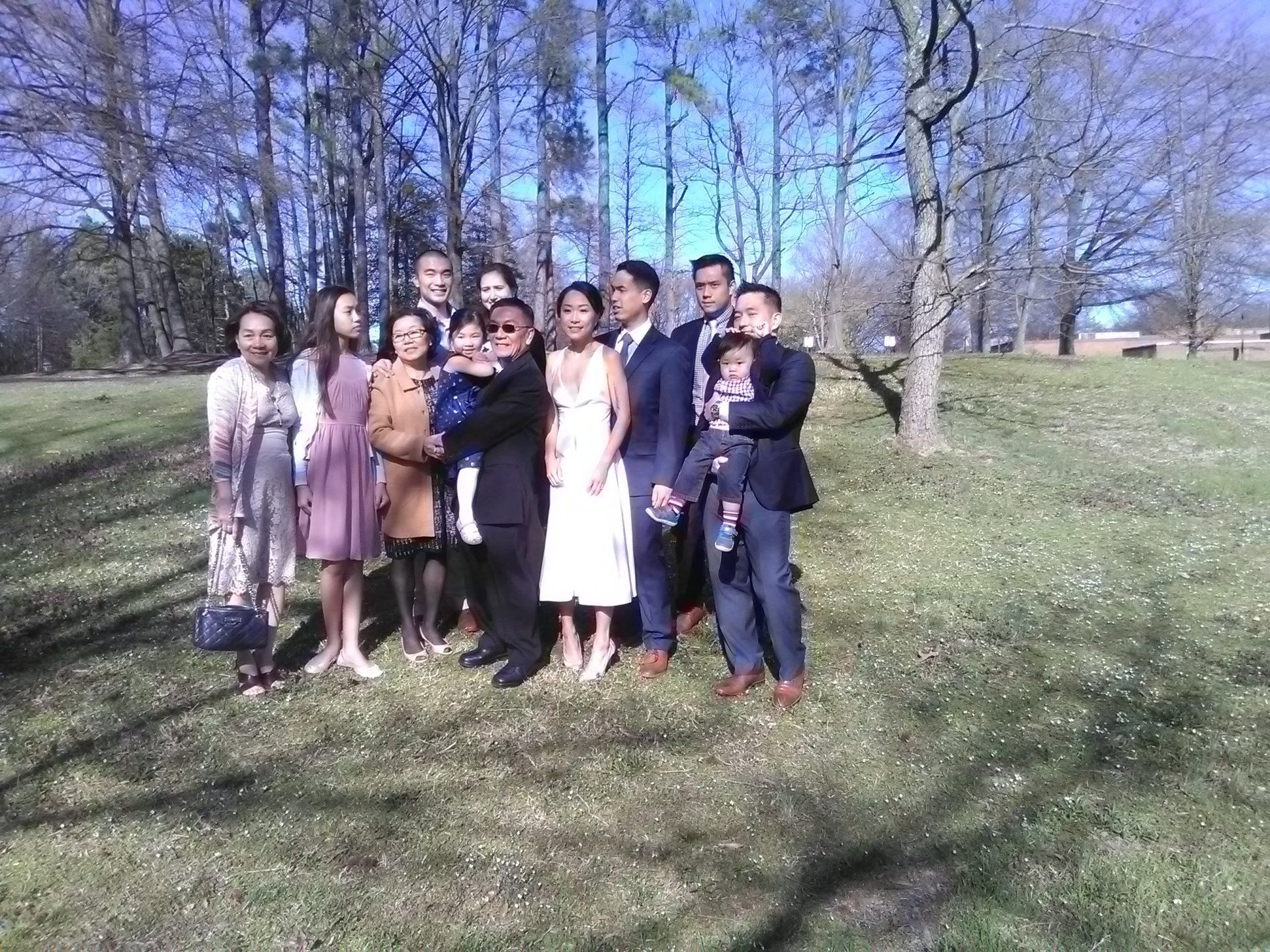 A group of people are posing for a picture in a park.