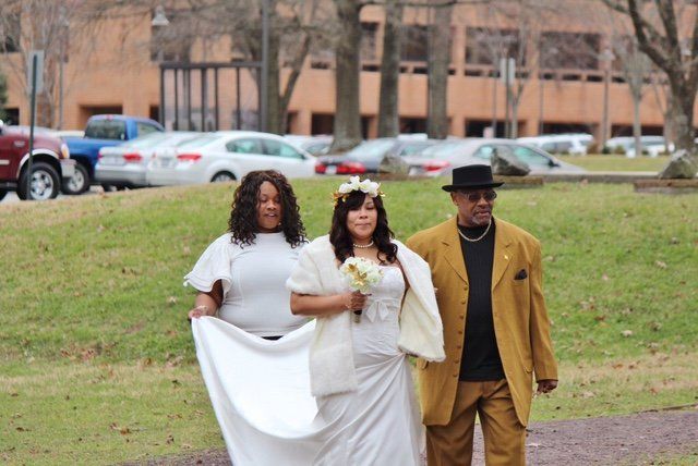 A bride is walking down the aisle with her parents