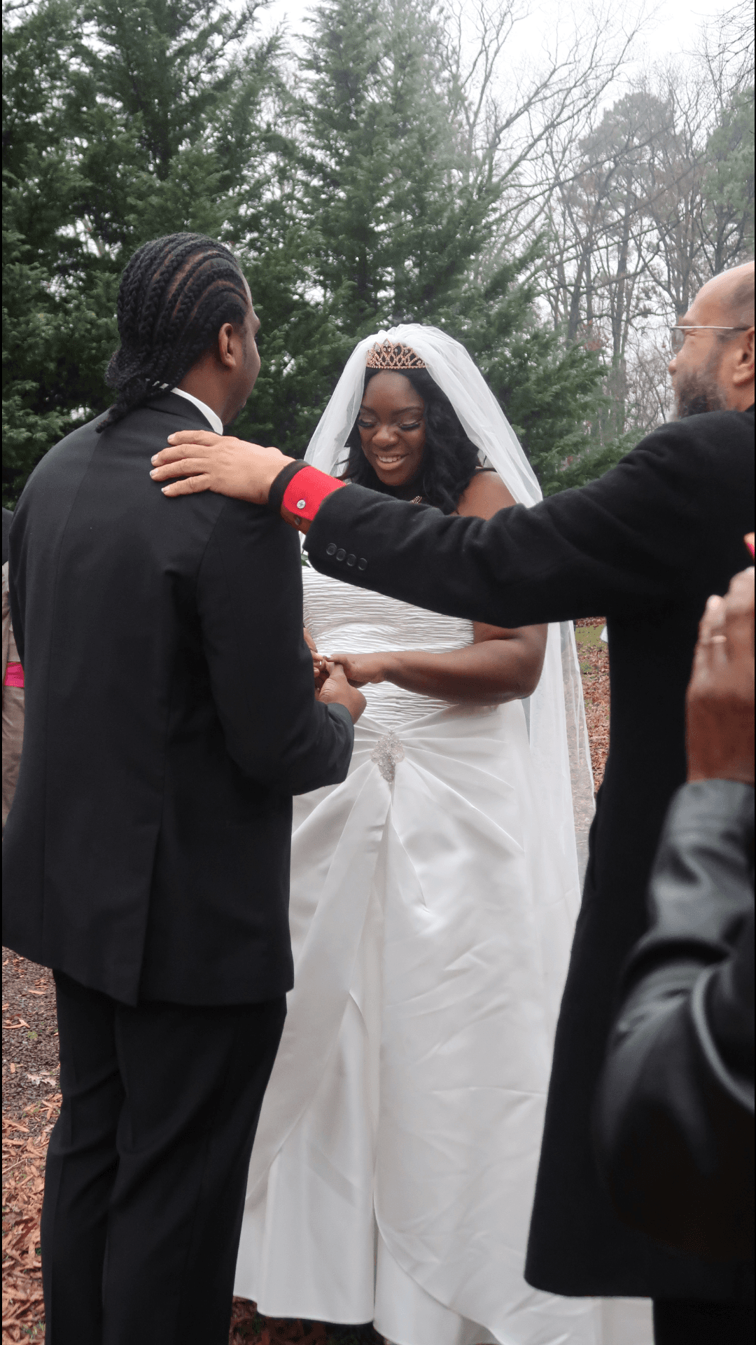 A bride and groom are holding hands during their wedding ceremony.