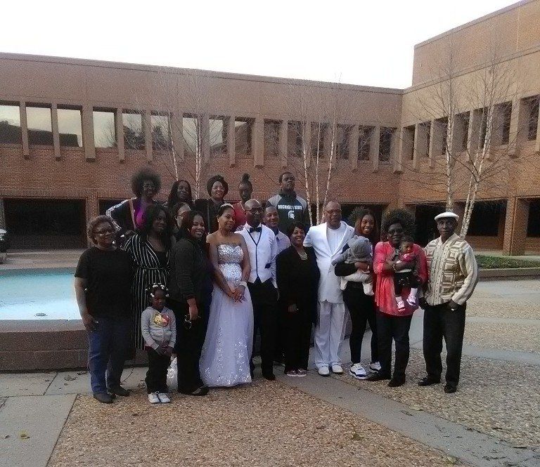 A group of people posing for a picture in front of a building