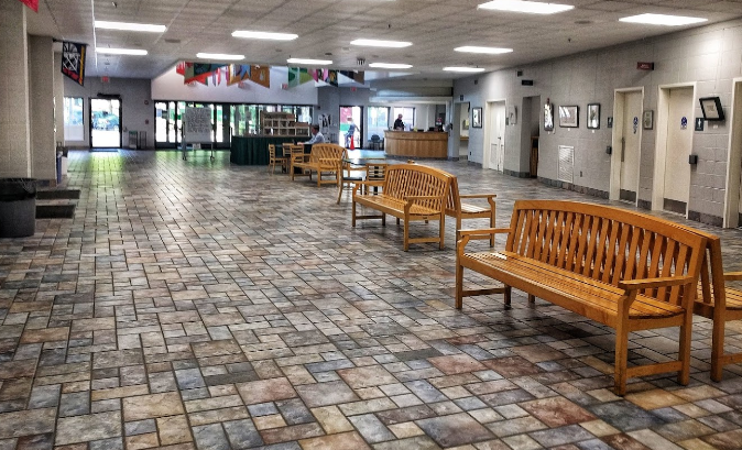 There are many benches in the lobby of a building.