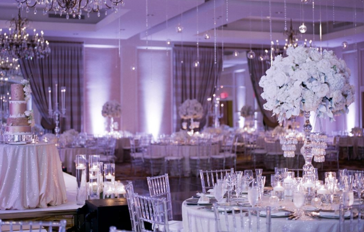 A large room with tables and chairs set up for a wedding reception.