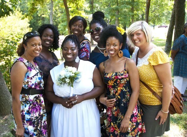 A group of women are posing for a picture in a park