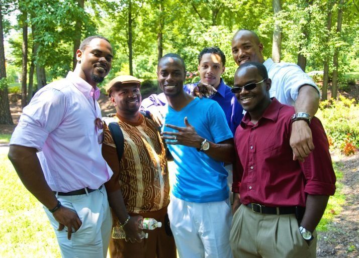 A group of men posing for a picture in a park