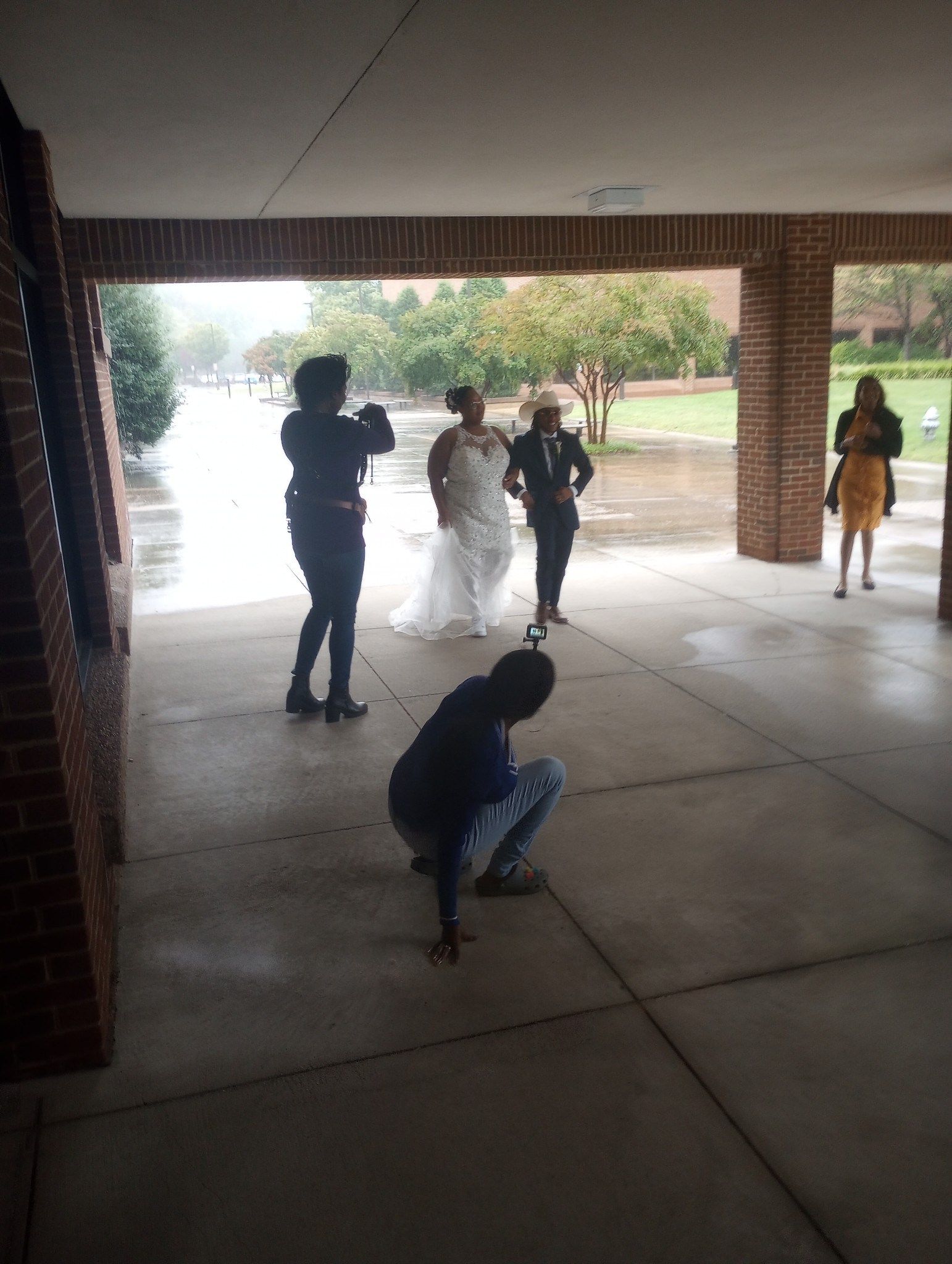 A bride and groom are being photographed by a group of people